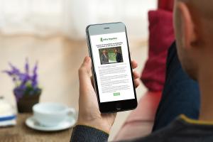 Image of person reading Utility Regulator newsletter via a SmartPhone