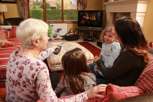 Family watching TV using electricity