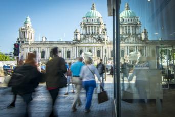 An image of Belfast City Hall and a busy shopping street